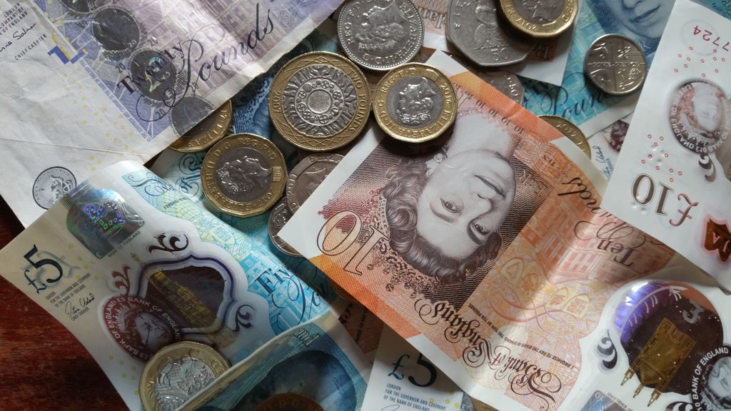 The Highest-Paying Jobs in the UK (2026) Close-up collection of British Pound notes and coins, showcasing UK currency.